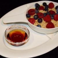 Steel Cut Oatmeal · Steel cut oatmeal with fresh fruit on top and maple syrup on the side.