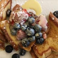 Creme Brulee French Toast · Three pieces, fresh cut strawberries and blueberries with creme anglaise and powdered sugar.