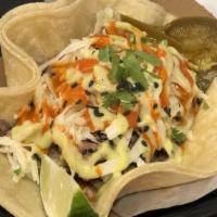 Taco · Single taco on two corn tortillas, topped with slaw, cilantro, sesame seeds, assorted sauces...