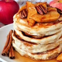 Apple Cinnamon Pancakes · Cinnamon flavored pancakes with finely chopped apples on top served with butter, whipped cre...