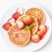 Strawberry Pancakes · Buttermilk pancakes topped with fresh strawberries served with butter, whipped cream and pow...