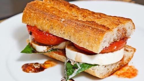 Caprese Sandwich · Sliced buffalo mozzarella, basil, Roma tomatoes, baby greens, balsamic reduction on a French baguette.