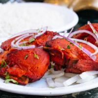 Chicken Tandoori · Half chicken marinated in yogurt and herbs, then barbecued.  Served with basmati rice.