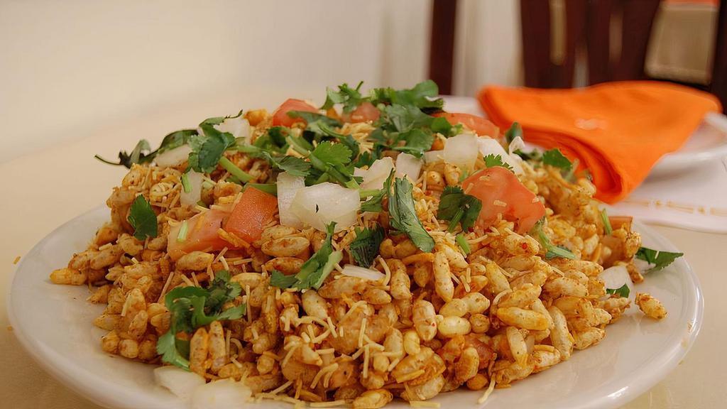 Bhel Puri · Puffed rice crisps, potatoes, onions, tomatoes, and chutney.