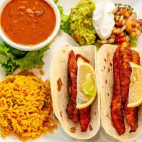 Fish Tacos · Specialty. Two flour tortillas filled with Tilapia, Mexican rice, refried beans, lettuce, pi...