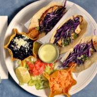 Baja Fish Tacos · Three soft corn tortillas with marinated grilled Tilapia fish and served with shredded cabba...