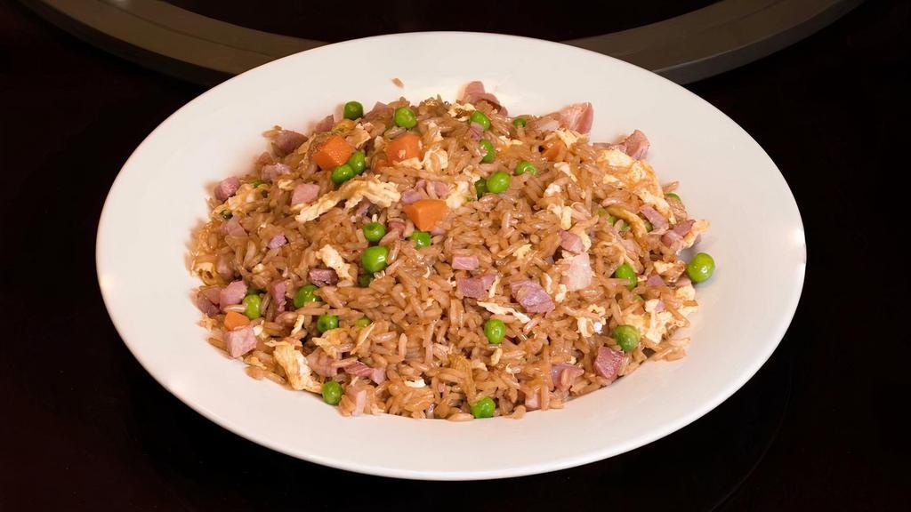 Pork Fried Rice 猪炒饭 · Chunks of ham fried with egg, green peas, carrots, onions, and cooked with rice to a golden glow.