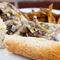 Ribeye Cheesesteak · Chopped ribeye with house made wiz and fried onion on a seeded Sarcone’s roll. Served with f...