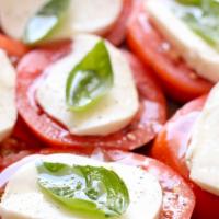 Caprese · Tomato with fresh mozzarella, basil, and roasted peppers, extra virgin olive oil.