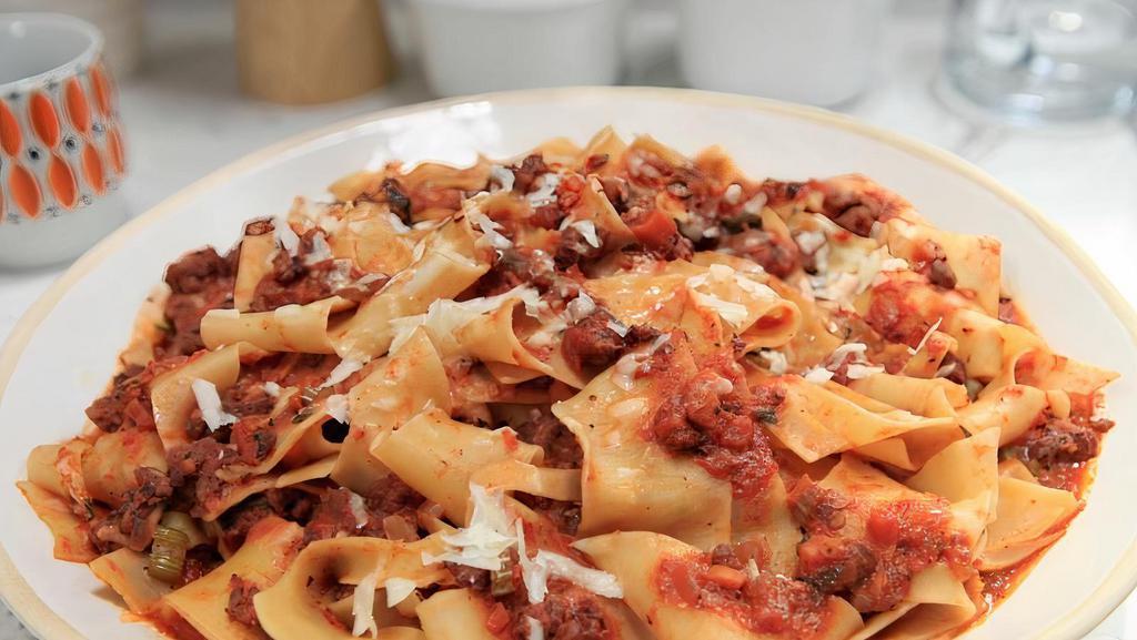 Fetuccini Bolognese · Pappardelle pasta with grounded beef, basil, carrots, and celery finished in red wine tomato sauce.
