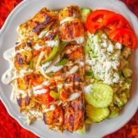 Chicken Kabob Plate · Two chicken skewers, one veggie skewer over rice, cucumber salad.