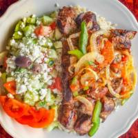 Lamb Kabob Plate · Two lamb skewers & a veggie skewer over rice, cucumber salad.