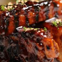 Our Ribs · Crispy tender pork ribs smothered in a sweet and spicy sauce.
