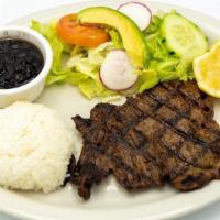 Carne Asada · Grilled beef steak served with rice, beans and salad.