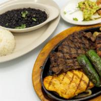 Parrillada Salvadoreña · Beef, chicken and sausage served with rice, beans, salad, sour cream, guacamole and pico de ...
