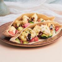 Cauliflower Pita Sandwich · Charred cauliflower with diced tomato and cucumber, chopped parsley, and a tahini drizzle wr...