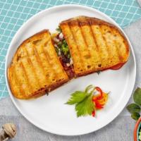 Turkey Club Panini · Turkey, ham, tomato, American cheese and mayo served on a flat panini bread.