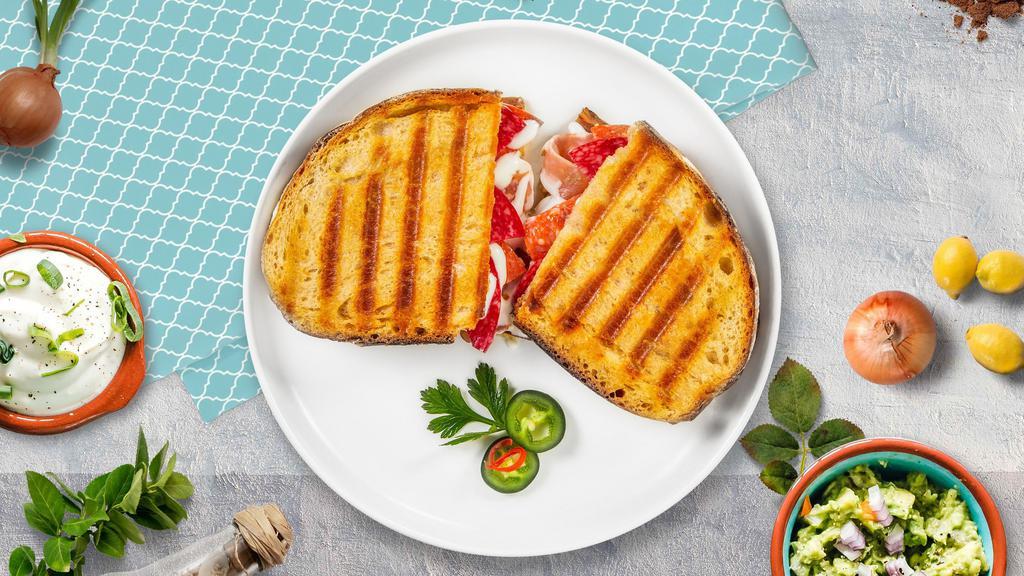 Prosciutto Express · Fresh mozzarella, prosciutto, tomatoes, fresh basil, imported extra virgin olive oil, herbs, salt and pepper served on a flat panini bread.
