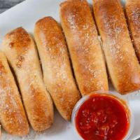 Homemade Breadsticks · Fresh baked bread sticks topped with garlic butter and Parmesan cheese, served with marinara.