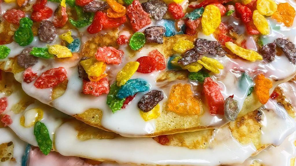 Fruity Pebbles Pancakes Platter · Our classic pancakes filled with fruity pebbles, layered with strawberry cream cheese, and topped with vanilla glaze served with your choice of side