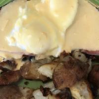 Eggs Benedict · Two dropped eggs on ham and an English muffin with benedict sauce on top, served with home f...