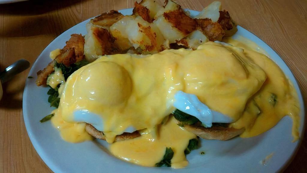Eggs Florentine · Two dropped eggs on spinach on an English muffin with benedict sauce on top, served with home fries.