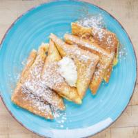 Side Of French Toast · Two slices of French toast topped with butter, cinnamon, and powdered sugar.