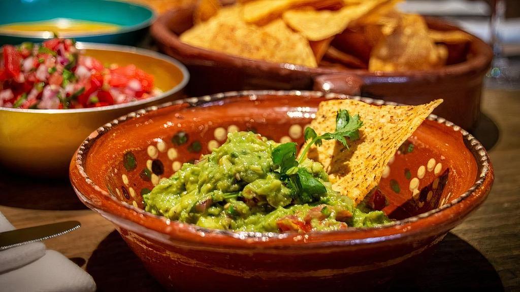 Chips & Guacamole (V) · Fresh tortilla chips served with ripe avocados blended with red onion, green chiles, tomatoes, cilantro and lime juice.