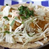 Fish Tacos (2) · Lightly fried Alaskan pollock served with shredded cabbage and creamy red salsa.