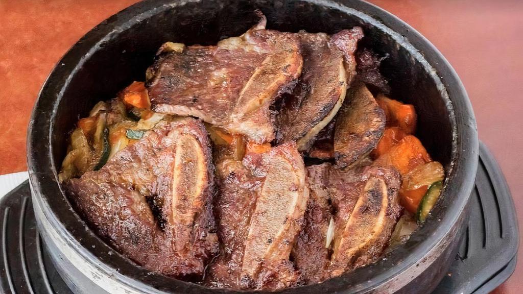 A. Kalbi Dolsot · Sizzling marinated beef short ribs with carrot, onion & zucchini.