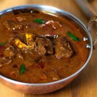 Goat Curry · Bone-in Goat meat prepared with tomato, onion sauce and ground spices. Served with basmati r...