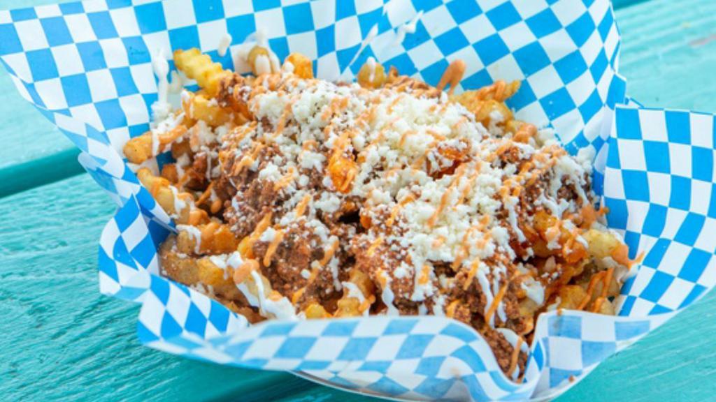Vaquero Fries · Full order of seasoned stealth fries, topped with our own chorizo, queso fresco, sour cream, diced onions, our secret chipotle sauce.
