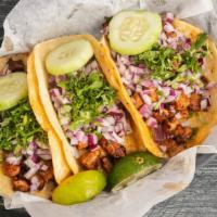 Mexican Street Tacos · Three soft corn tortilla tacos filled with your choice of meat topped with chopped cilantro ...