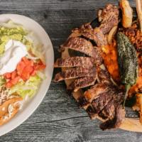 Molcajete · Famous Mexican dish cooked in a lava stone with grilled rib-eye steak, chicken, chorizo, shr...
