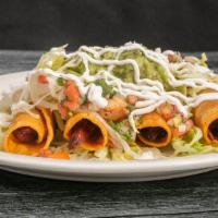 Taquitos Mexicanos · Two beef and two chicken fried corn taquitos topped with lettuce, guacamole, sour cream and ...