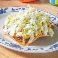 Tostada · A tostada is a flat fried tortilla with your choices below, it is topped with beans, your ch...