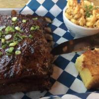Kansas City Ribs · Full rack of barbecued pork ribs with mac n' cheese, potato salad, and house pickles.