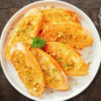 Genius Garlic Bread · Housemade bread toasted and garnished with butter, garlic, and parsley.