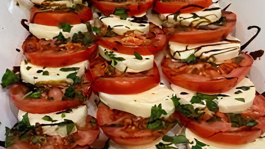 Caprese · Fresh layered mozzarella, tomato, drizzled with balsamic reduction over arugula and basil infused oil.