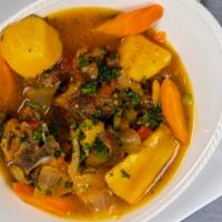 Cabritada · Stewed goat with yucca, carrots and potatoes served with rice.