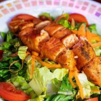 Salmon Salad · Crisp greens topped with grilled or jerked salmon and a combination of fresh vegetables.