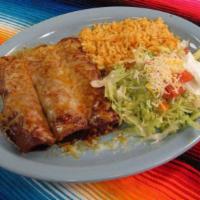 Combination Enchiladas · Four combination enchiladas, one chicken, one cheese, one bean, one beef, covered with salad.