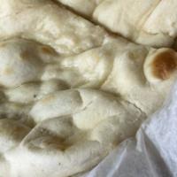 Naan · Traditional white bread baked in a clay oven.