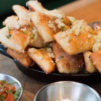 Parmesan Garlic Knots · Savory dough tossed in a garlic herb butter with parmesan and baked. Served with whipped ric...