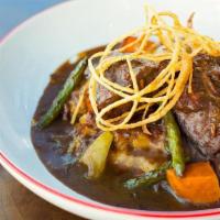 Yankee Pot Roast · Tender beef slow-braised in a whiskey gravy with root vegetables and green beans. Served ove...