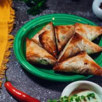 Spanakopita · Filo dough triangles stuffed with sauteed spinach and feta cheese baked to a golden crisp. S...