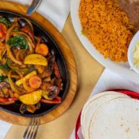 Veggie Fajitas · A sizzling cast iron skillet filled with our veggie mix. Served with Mexican rice, refried b...