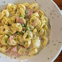 Tortellini Nicole · Cheese-filled tortellini tossed in a homemade Alfredo sauce with peas and imported ham.