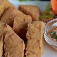 Tofu Triangles · Golden fried tofu served with sweet, sour sauce, and crushed peanuts.