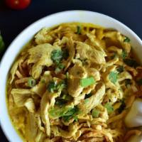 Khao Soi · Spicy.  Flat egg noodle with sliced chicken in light yellow curry sauce. Topped with crisp e...